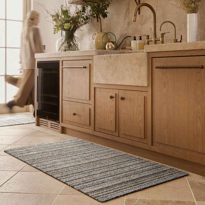 Ribbon Grey Striped Washable Runner- a 100% recycled material runner featuring a subtle striped pattern in shades of beige, light brown, and blue.