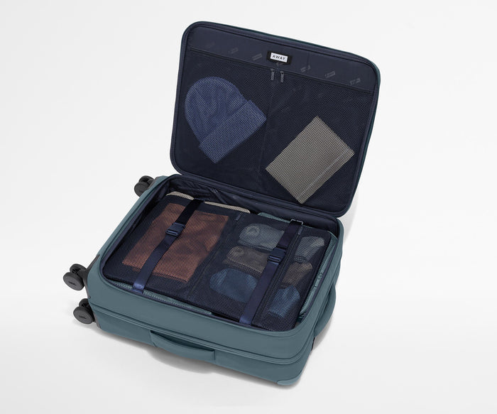 Open Softside suitcase, with travel essentials in the front flap pocket and compression pad pockets