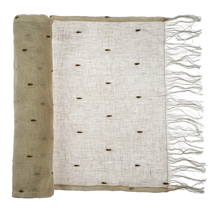 beige linen table runner with black teardrop embroidery.