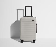 Front product view of The Carry-On suitcase in Cloud Gray with raised handle