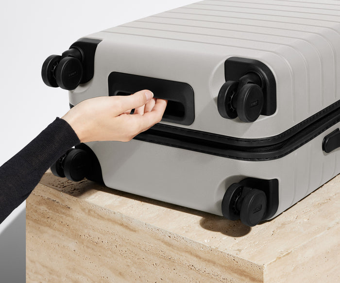 The Carry-On suitcase in Cloud Gray shown from below highlighting the underside grab handle
// 
Underside grab handle that makes it easier to lift and carry your suitcase.